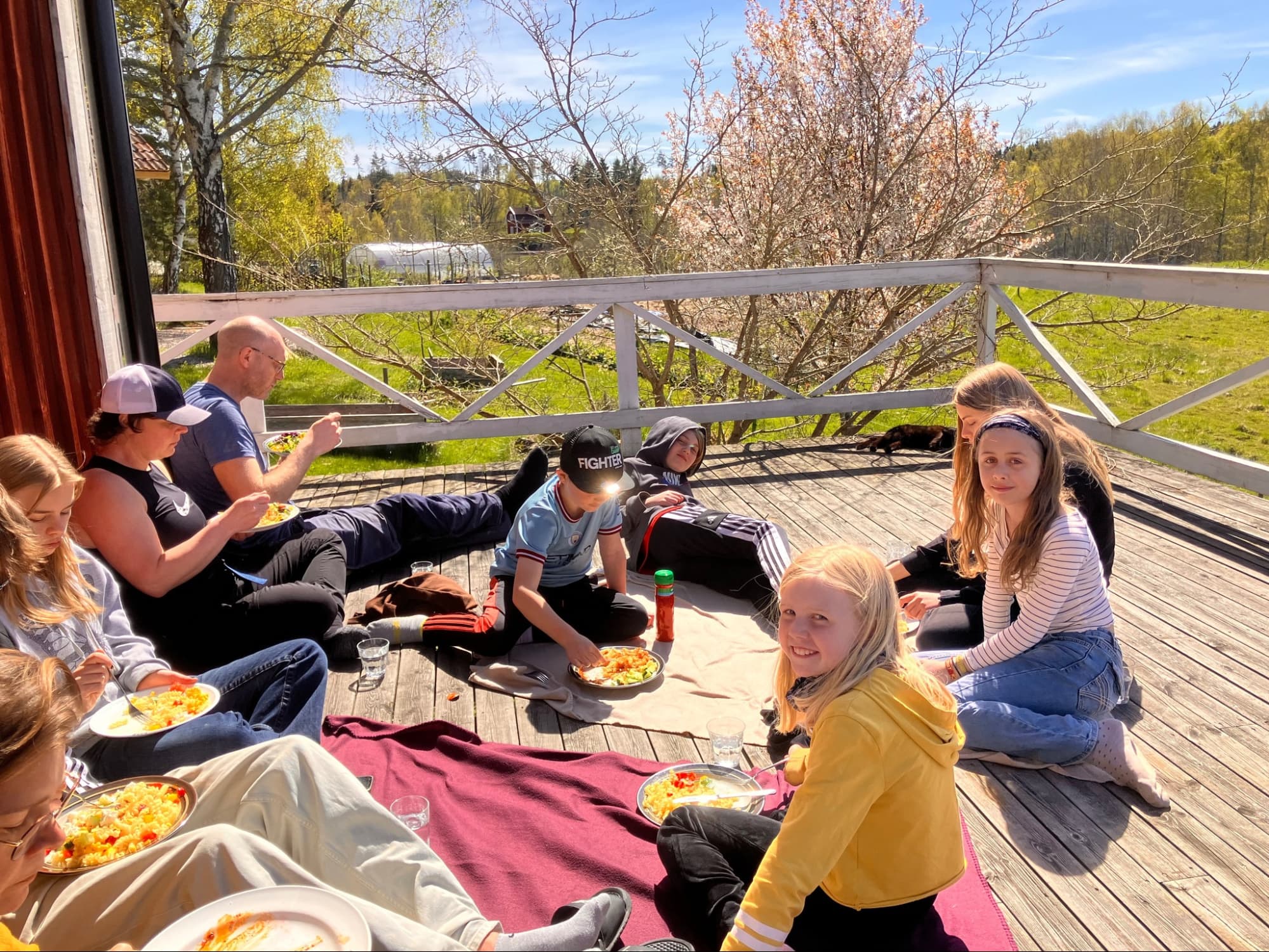 Bild: Folk äter mat i solen på altanen